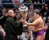 　初優勝を果たし、賜杯を受け取る尊富士（右）