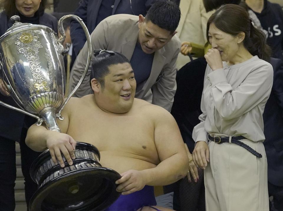 　大相撲春場所で優勝し、賜杯を手に笑顔で母親の石岡桃子さん（右）と話す尊富士