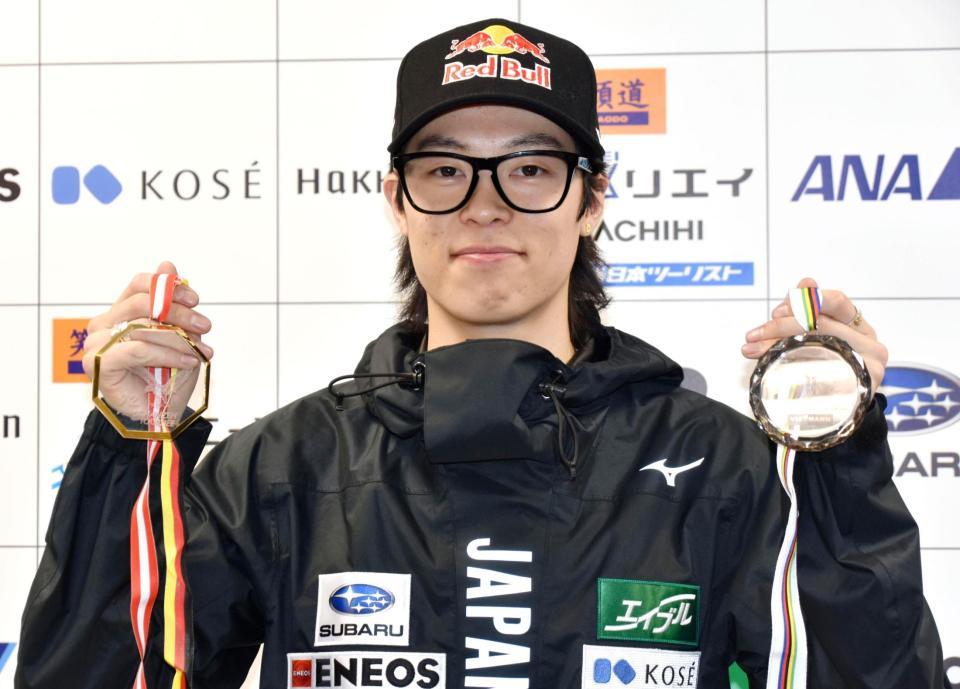 　記者会見で、ジャンプ週間優勝とＷ杯個人総合のメダルを見せる小林陵侑（共同）