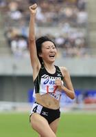 　日本選手権の女子５０００メートルで初優勝しガッツポーズで喜ぶ絹川愛さん＝２０１１年