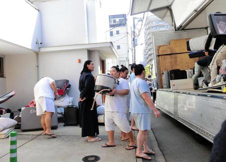 　伊勢ケ浜部屋の前で荷物をトラックから下ろす力士たち