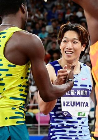　男子１１０メートル障害のレース後、笑顔で健闘をたたえ合う泉谷駿介