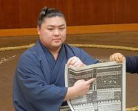 　新入幕を果たし、番付表を持つ時疾風