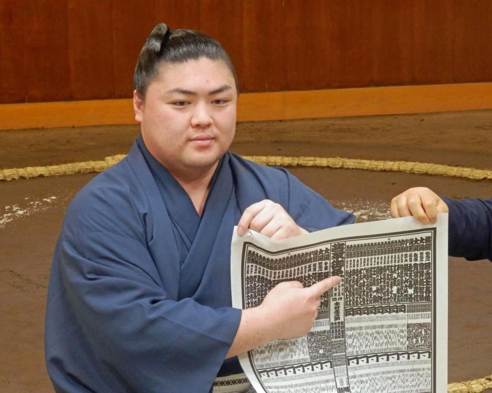 　新入幕を果たし、番付表を持つ時疾風