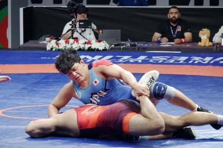 　レスリングのパリ五輪世界最終予選男子フリースタイル９７キロ級の初戦を闘う吉田アラシ（上）＝イスタンブール（共同）