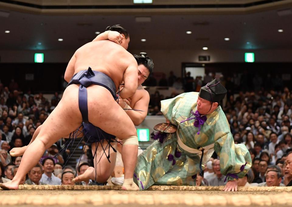 　豊昇龍（左手前）に寄り倒しで敗れた平戸海を避けて転倒する行司（撮影・開出牧）