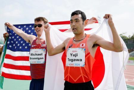 　男子１５００メートル（知的障害）で銅メダルを獲得し、日の丸を掲げる十川裕次（右）＝神戸ユニバー記念競技場