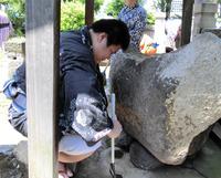 　神社の手水舎（ちょうずしゃ）をほうきで掃く