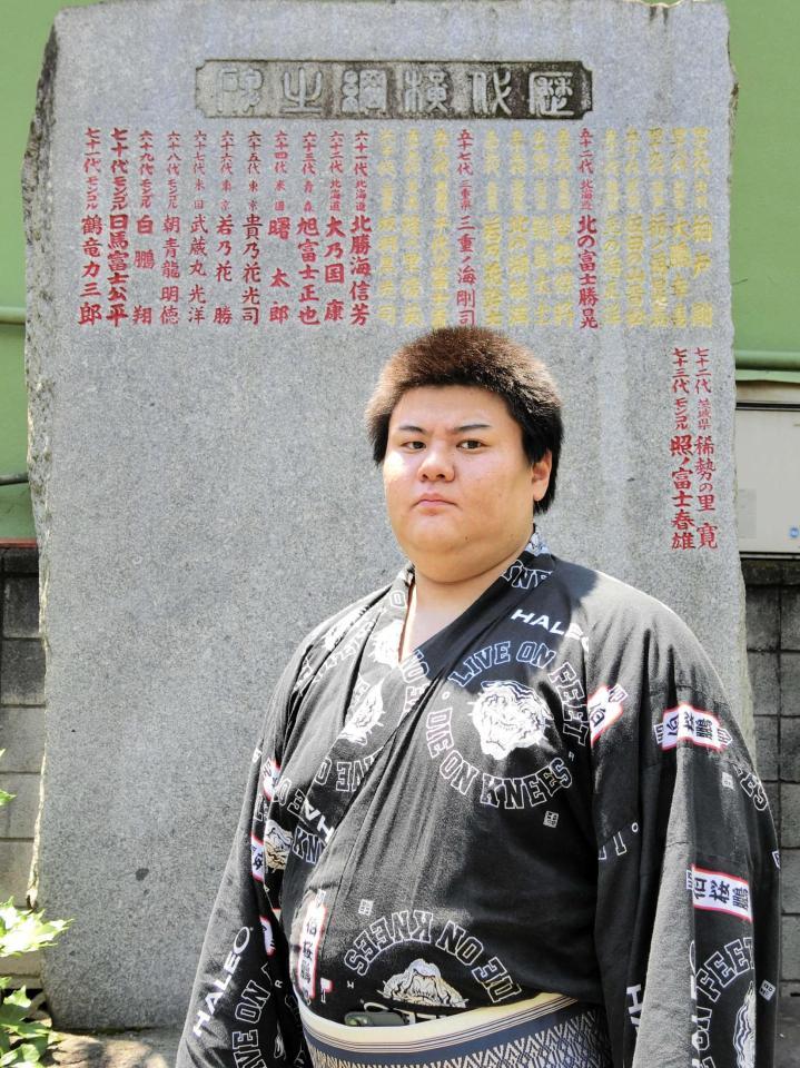 　歴代横綱のしこ名が刻まれた石碑の前に立つ草野