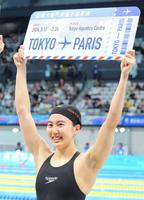 　女子２００メートル個人メドレーでパリ五輪代表に決まり、ボードを手に笑顔の松本信歩３月２４日