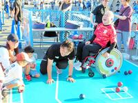 　Ｊ１川崎のスタジアム場外での特設ブースで子どもたちとボッチャ体験会で笑顔を見せるパリパラリンピック混合団体銅メダルの広瀬隆喜