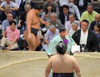 　王鵬（手前）に敗れ、礼をする前に土俵を降りた豊昇龍は、うつむきながら再び土俵に戻る（撮影・吉澤敬太）