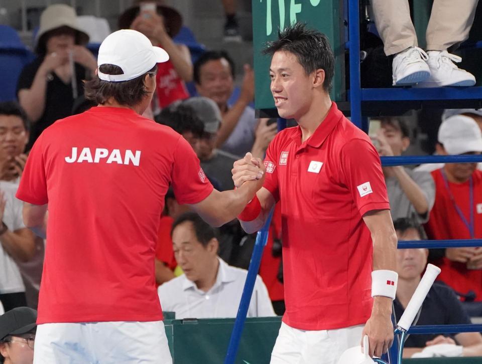 　シングルスで勝利し添田豪監督（左）とがっちタッチを交わす錦織圭（撮影・開出牧）