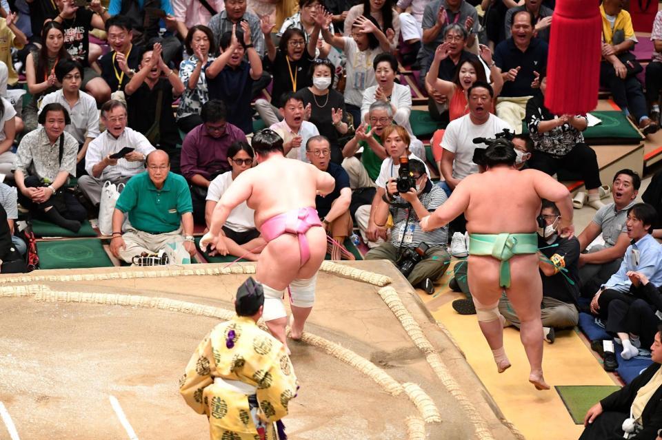 　琴桜（右）を押し出しで破った宇良。館内に拍手と大歓声が響き渡る（撮影・開出牧）