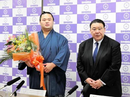 　引退会見を終え、花束を贈られた元関脇妙義龍の振分親方（左）と師匠の境川親方