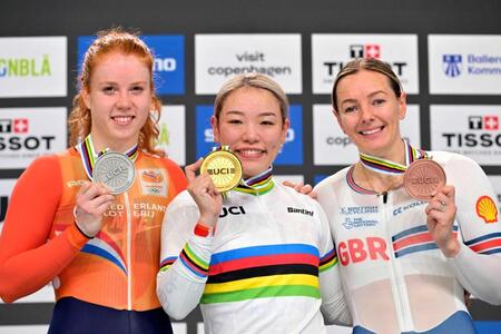 　自転車トラック種目の世界選手権で女子ケイリンを日本勢で初制覇し、金メダルを手にする佐藤水菜（中央）＝共同