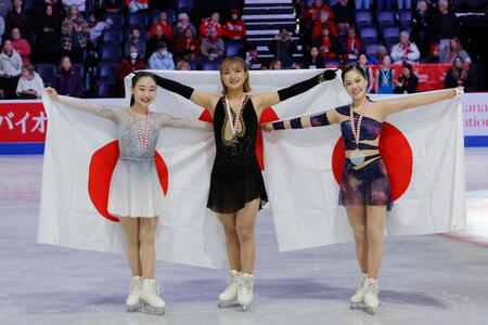 　日の丸を掲げる優勝した坂本花織（中央）と２位の松生理乃（左）、３位の吉田陽菜