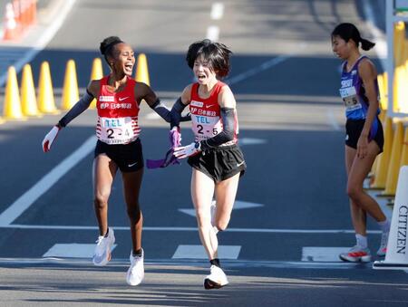 　４区のカロライン・カリバ（左）からたすきを受け取る日本郵政グループの鈴木亜由子。右は積水化学の新谷仁美