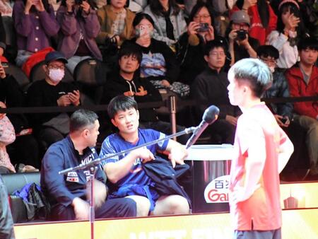 　世界１位の王楚欽（右）に完敗し、優勝インタビューを聞きながら日本代表の田勢コーチ（左）と話し込む張本智和