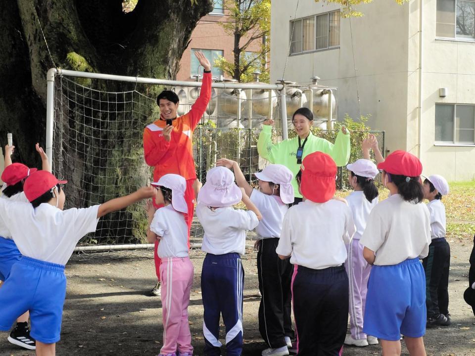 　子供たちと触れ合う（左奧の）石川周平と田中佑美＝筑波大学附属聴覚特別支援学校小学部