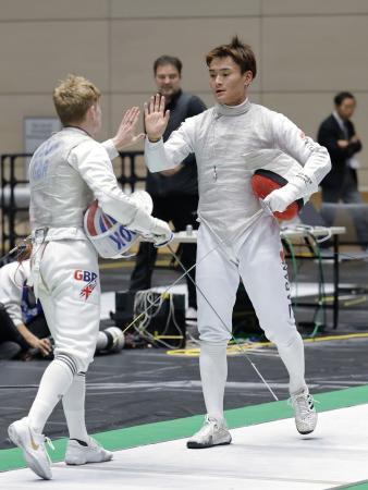 　決勝トーナメント３回戦で英国選手（左）に敗れ、タッチを交わす松山恭助＝高崎アリーナ