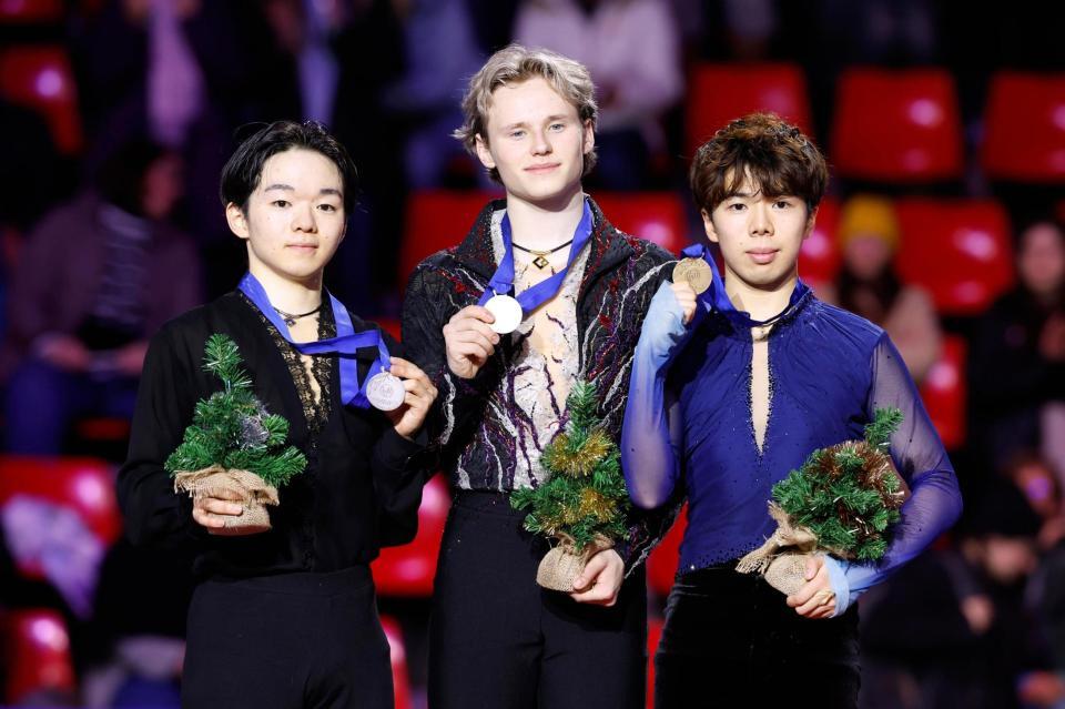 男子の表彰式でメダルを掲げる（左から）２位の鍵山優真、優勝のイリア・マリニン、３位の佐藤駿（共同）