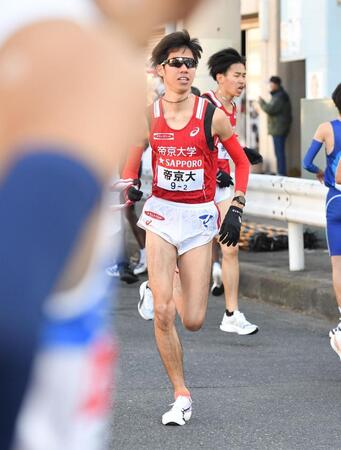 島田晃希（右後方）からたすきを受け駆け出す帝京大・山中博生（撮影・開出牧）