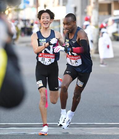 安藤風羽（左）からたすきを受け駆け出す日大のシャドラック・キップケメイ（撮影・開出牧）