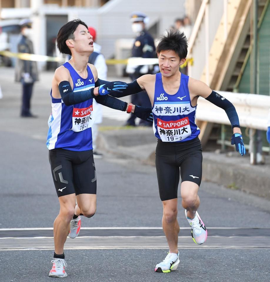 大岩蓮（左）からたすきを受ける神奈川大・宮本陽叶（撮影・開出牧）