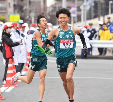 　塩出翔太（後方）からたすきを受け駆け出す青学大・田中悠登（撮影・開出牧）