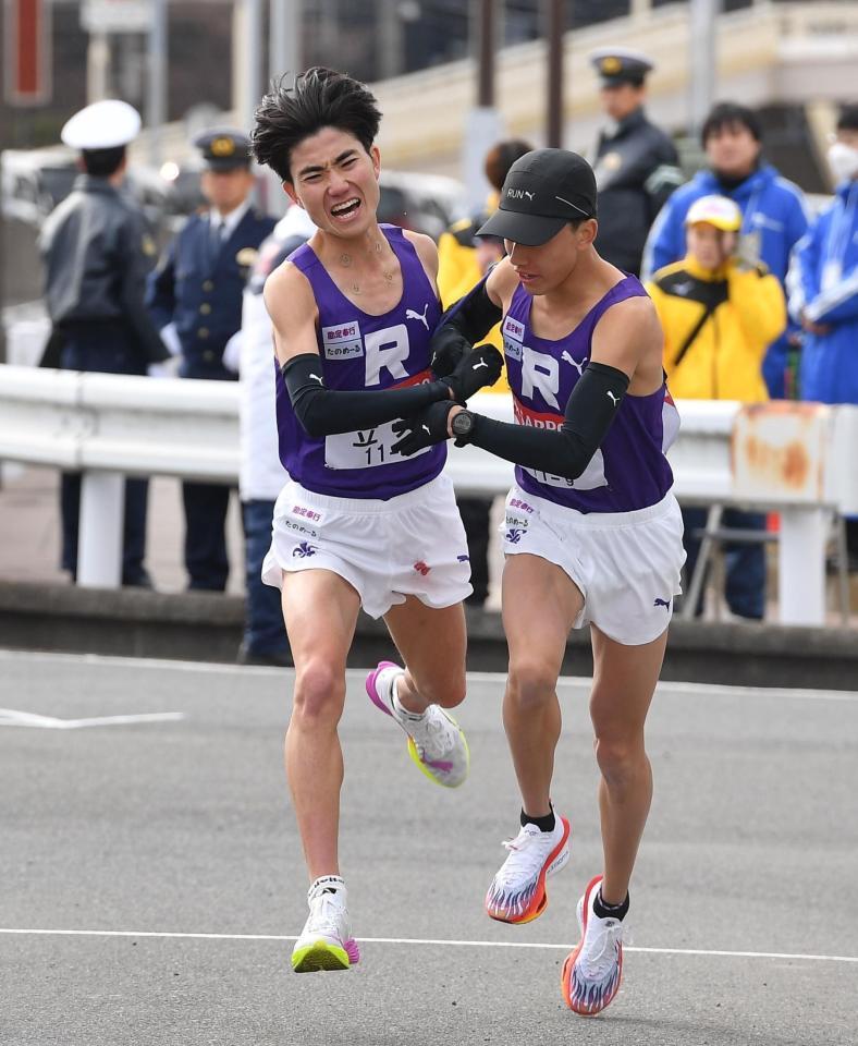 　安藤圭佑（右）にたすきを渡す立大・山口史朗（撮影・開出牧）