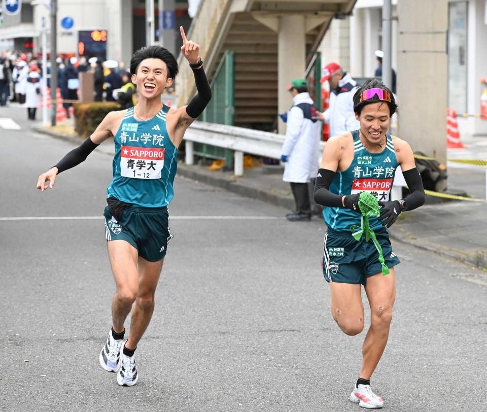 　小河原（右）にたすきをつなぎ、人さし指を突き上げる青学大・田中主将（撮影・堀内翔）