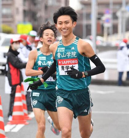 　塩出翔太（後方）からたすきを受け笑顔で駆け出す青学大・田中悠登（３日）