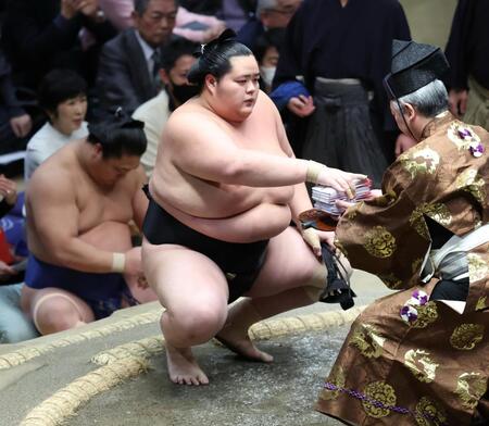 　上手出し投げで王鵬を下し、懸賞金を受け取る琴桜