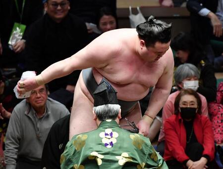 　懸賞の束を受け取る金峰山（撮影・佐藤厚）