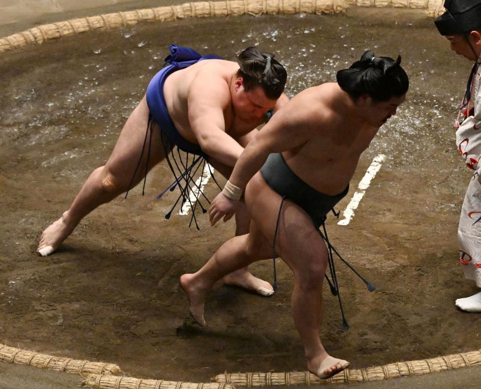 　安青錦（左）は送り出しで朝紅龍を破る