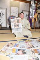 　千秋楽から一夜明け、デイリースポーツを手に笑顔の豊昇龍（撮影・開出牧）