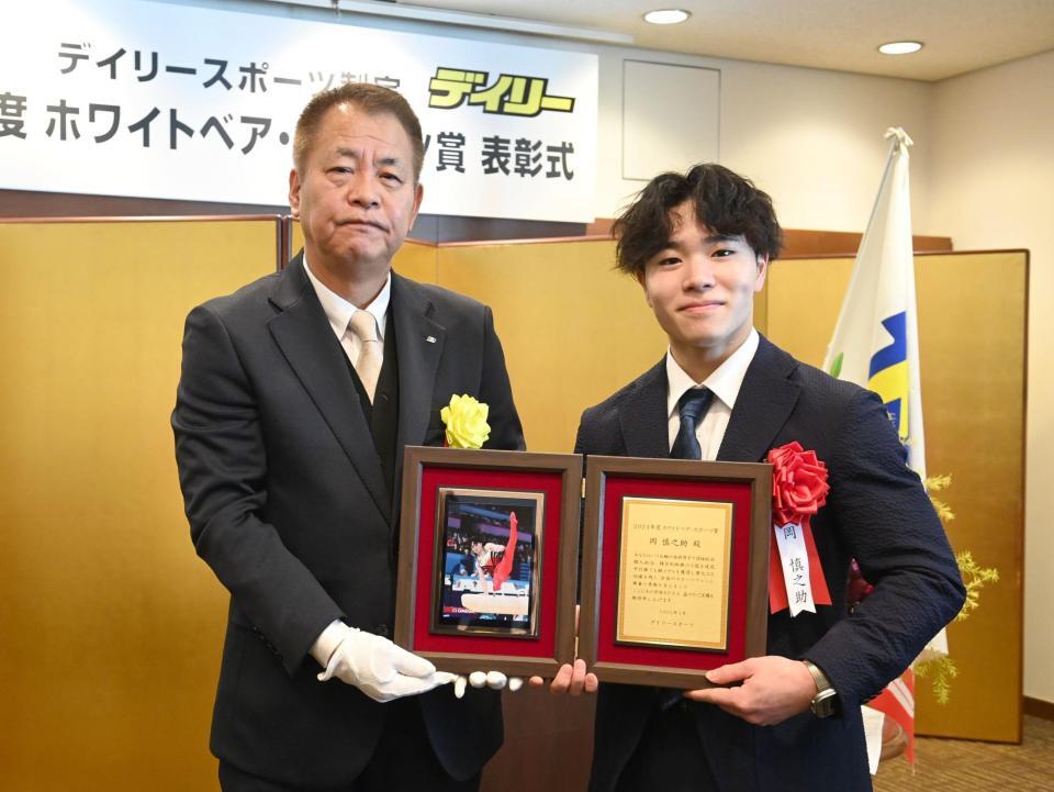 　デイリースポーツ・藤谷稔社長（左）から記念の盾を手渡される岡慎之助（撮影・園田高夫）