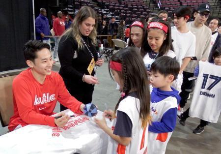 　自身のレプリカユニホームを着たファンにサインするＮＢＡ下部リーグ、ハッスルの河村（左端）＝１月３１日、サウスヘイブン（共同）