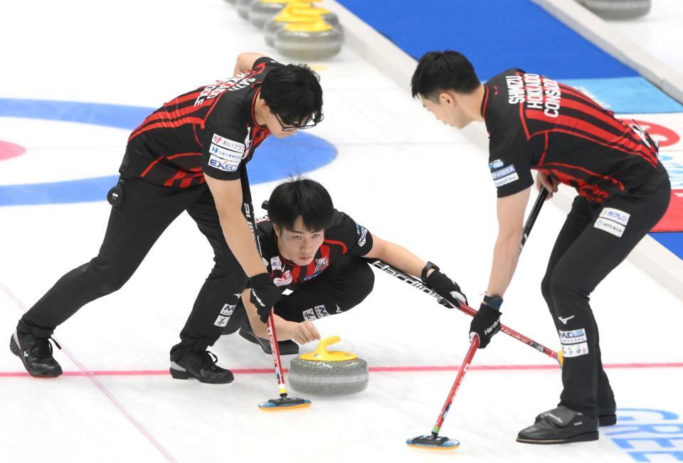 　ストーンを投じるコンサドーレ・大内遥斗（中央）（撮影・堀内翔）