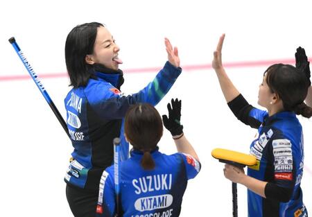 　第７エンドを終えて舌を出しながらタッチを交わすロコ・ソラーレの藤沢五月（撮影・堀内翔）