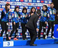 　記念撮影の時にプレゼンターが間違えて表彰台に上がってしまい、笑顔を見せるロコ・ソラーレの選手たち（横浜ＢＵＮＴＡＩ）＝９日