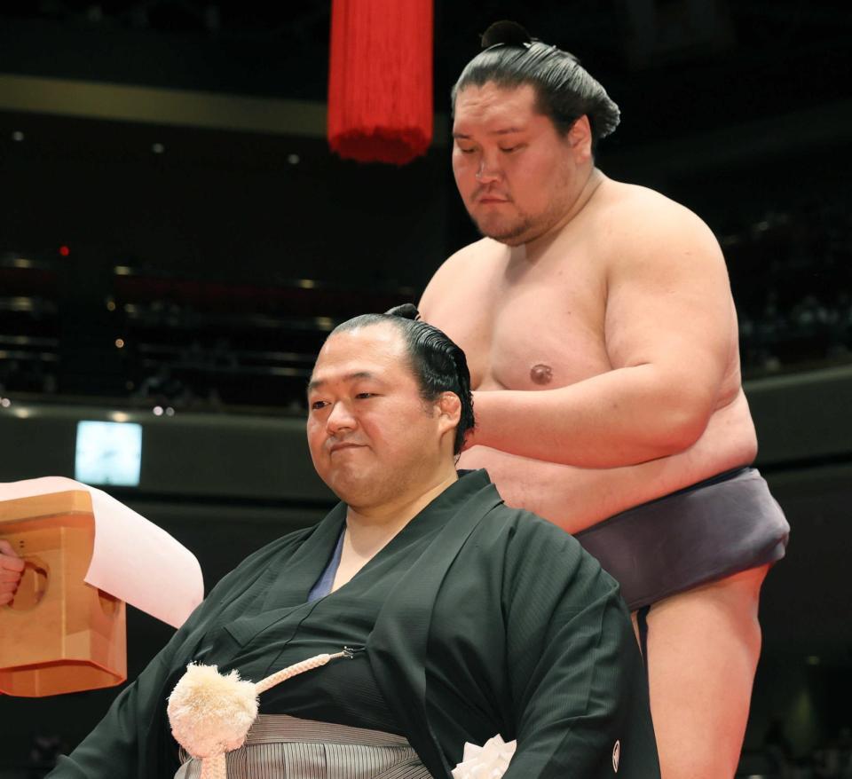 　断髪式で照ノ富士（右）にはさみを入れてもらう元豊ノ島の井筒親方（代表撮影）＝２２年５月