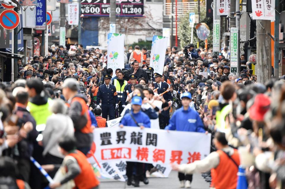 　人力車に乗ってパレードに集まった大勢のファンに手を振る豊昇龍（後方中央）＝撮影・開出牧