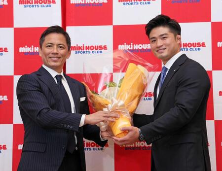 　野村忠宏氏（左）から花束を手渡される丸山城志郎
