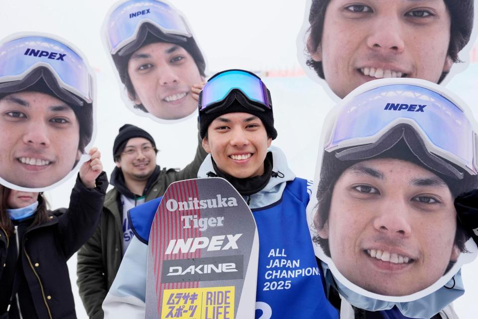 　３年ぶり２度目の優勝を決め、自身の写真パネルを掲げたチーム関係者と写真に納まる平野流佳