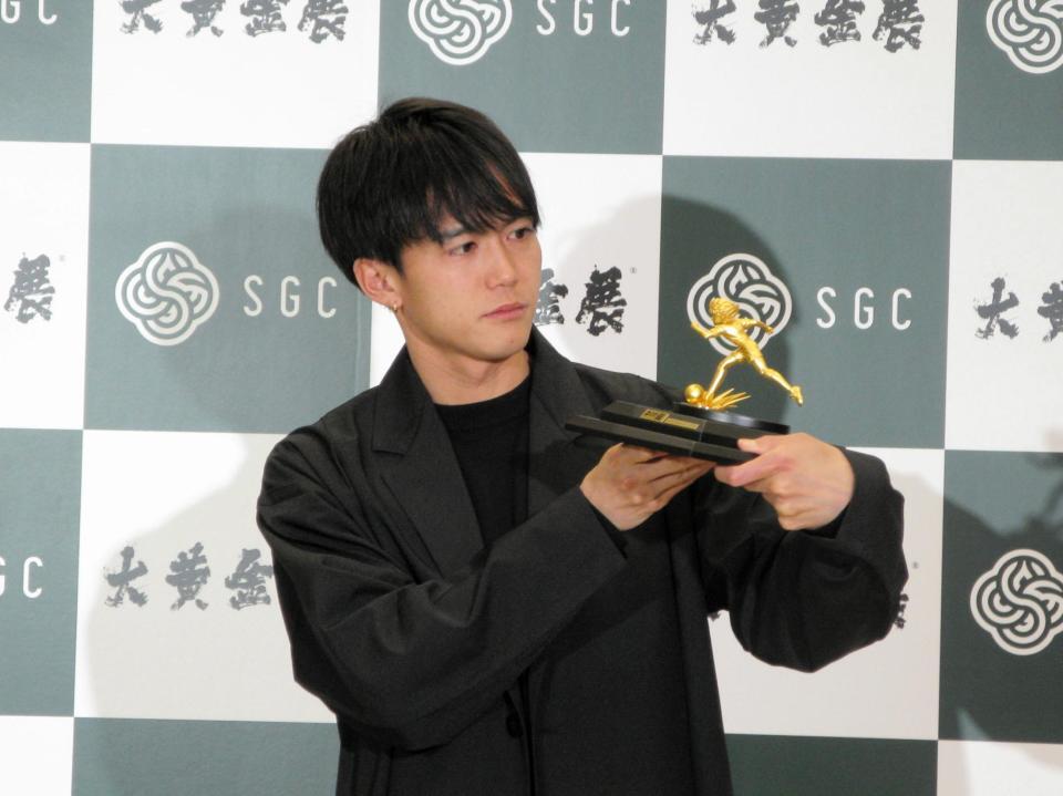 　「キャプテン翼」大空翼のミニチュア黄金モデルを見つめる大迫傑