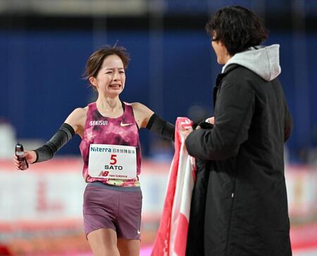 　日本人トップの２位でゴールし野口英盛監督（右）に迎えられる佐藤早也伽