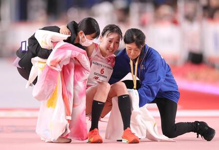 　日本人５位の１０位でゴールして倒れ込み抱えられる五島莉乃（中央）