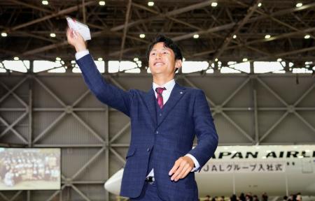 　ＪＡＬ入社式で、紙飛行機を飛ばす陸上の鵜沢飛羽＝１日午後、東京都大田区